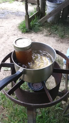 bees wax in jar inside pot of boiling water